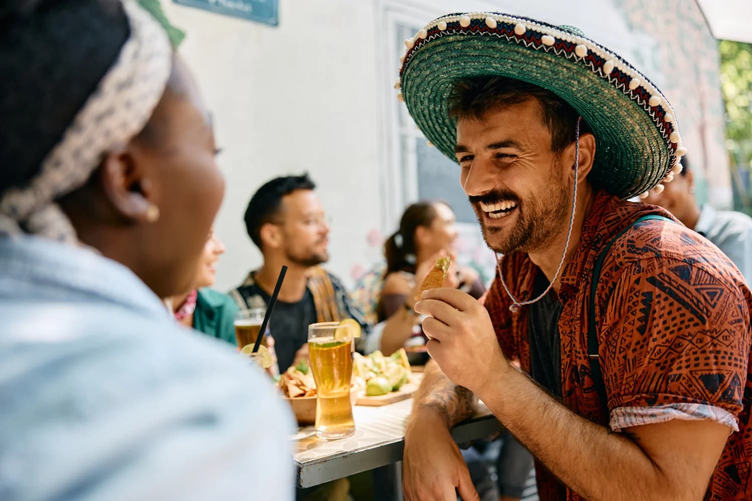 cheerful man eating nacho chips and drinking beer